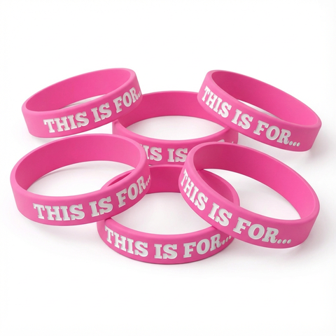 Multiple pink This Is For reminder wristbands on a white background
